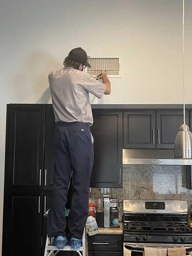 Technician inspecting an air vent during HVAC service in Wappingers Falls